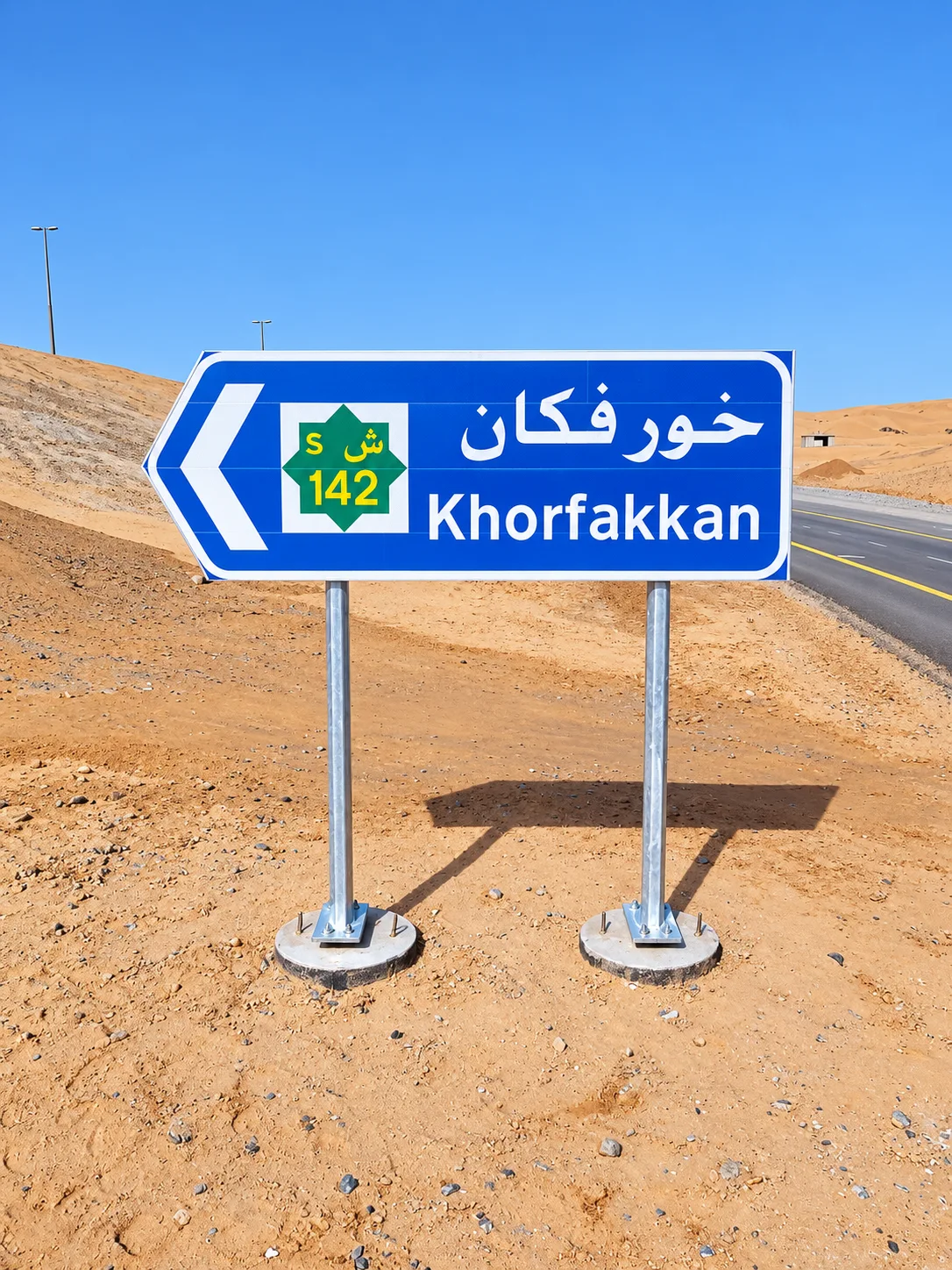 Blue sign to Khorfakkan in sandy landscape, illustrative capability imagery only